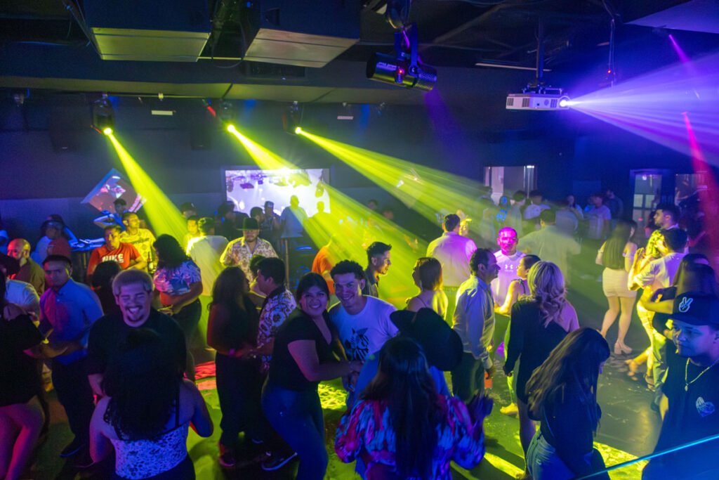Vista desde cabina de DJ hacia público bailando en club latino Houston