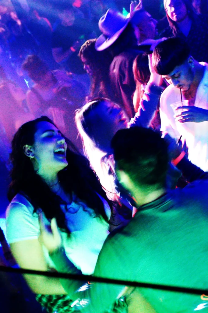 Grupo de amigos riendo y bailando en fiesta latina