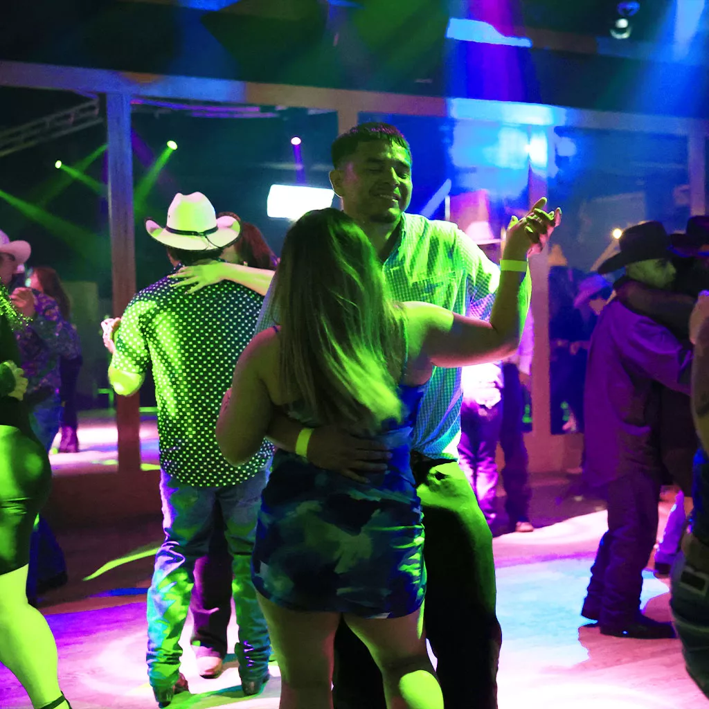Pareja bailando música norteña en Arriba el Norte de Escapade 2001 durante una noche latina en Houston