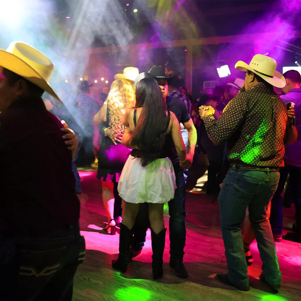 Personas bailando música norteña en Arriba el Norte de Escapade 2001, el club latino más grande de Houston